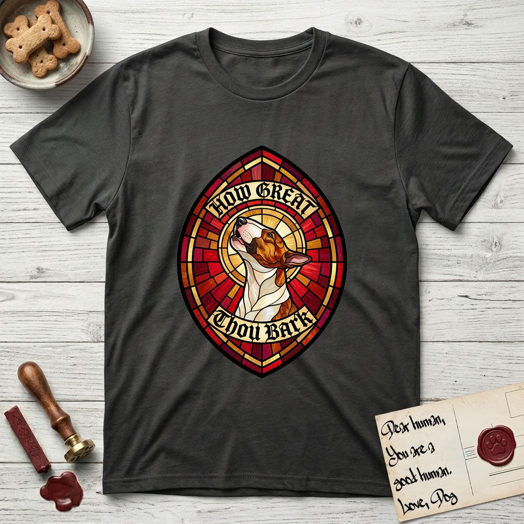 How Great Thou Bark Bull Terrier T-Shirt flat lay in Charcoal, featuring a full-color stained-glass saint window of a brown and white Bull Terrier with head raised and mouth open mid-howl, haloed in golden light.