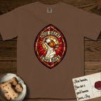 How Great Thou Bark Bull Terrier T-Shirt flat lay in Espresso, featuring a full-color stained-glass saint window of a brown and white Bull Terrier with head raised and mouth open mid-howl, haloed in golden light.