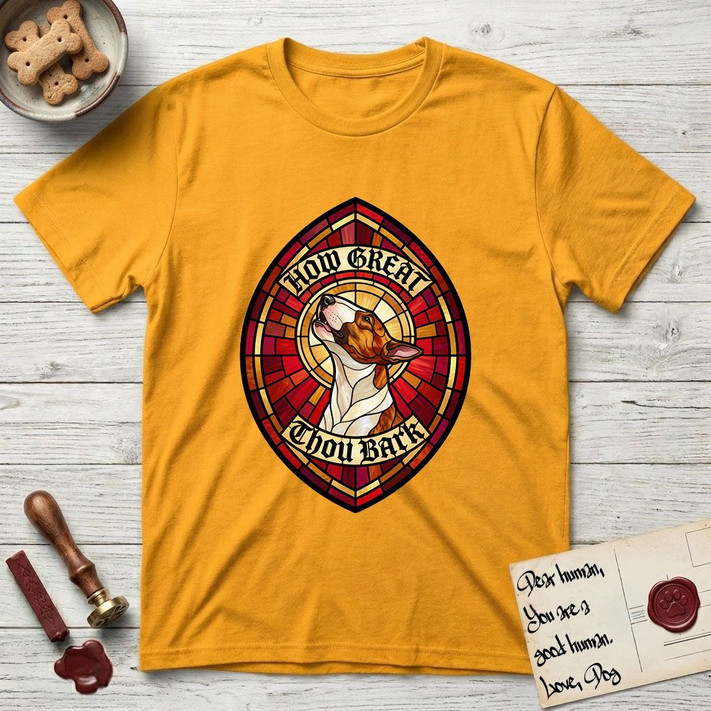 How Great Thou Bark Bull Terrier T-Shirt flat lay in Gold, featuring a full-color stained-glass saint window of a brown and white Bull Terrier with head raised and mouth open mid-howl, haloed in golden light.