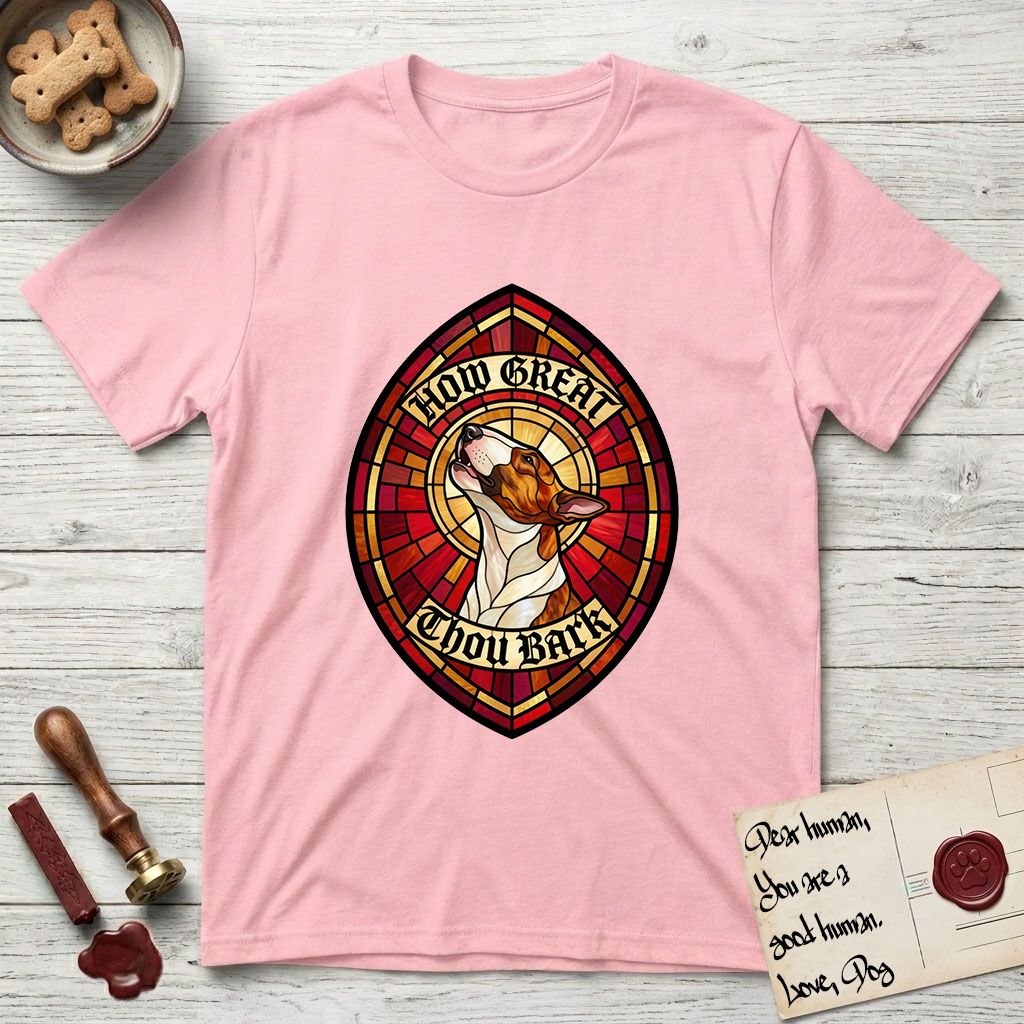 How Great Thou Bark Bull Terrier T-Shirt flat lay in Light Pink, featuring a full-color stained-glass saint window of a brown and white Bull Terrier with head raised and mouth open mid-howl, haloed in golden light.