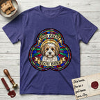 How Great Thou Bark Coton de Tulear T-Shirt flat lay in Metro Blue, featuring a full-color stained-glass saint window of a sable and white Coton de Tulear facing forward, haloed in golden light.