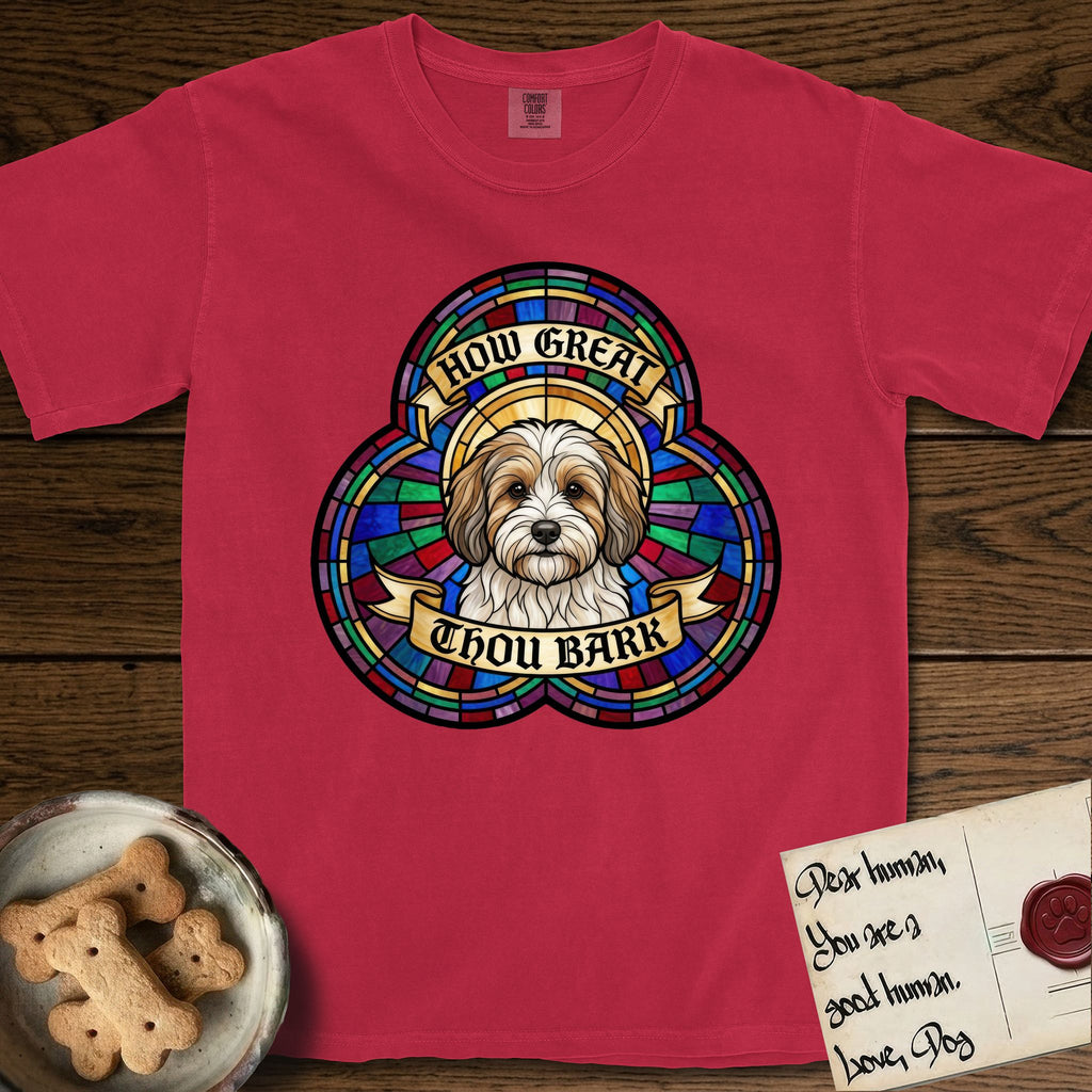 How Great Thou Bark Coton de Tulear T-Shirt flat lay in Red, featuring a full-color stained-glass saint window of a sable and white Coton de Tulear facing forward, haloed in golden light.