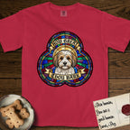How Great Thou Bark Coton de Tulear T-Shirt flat lay in Red, featuring a full-color stained-glass saint window of a sable and white Coton de Tulear facing forward, haloed in golden light.
