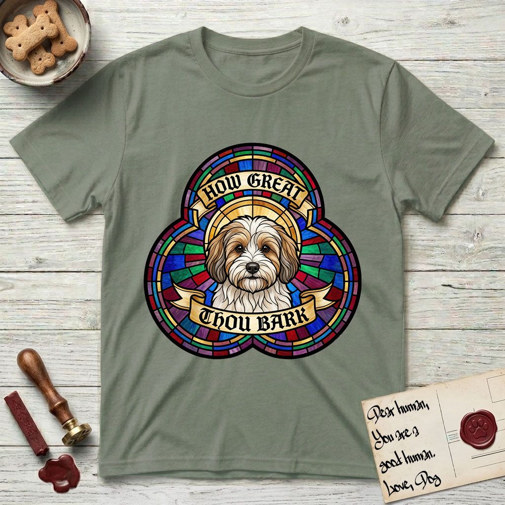 How Great Thou Bark Coton de Tulear T-Shirt flat lay in Sage, featuring a full-color stained-glass saint window of a sable and white Coton de Tulear facing forward, haloed in golden light.