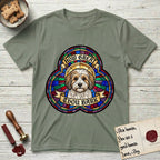 How Great Thou Bark Coton de Tulear T-Shirt flat lay in Sage, featuring a full-color stained-glass saint window of a sable and white Coton de Tulear facing forward, haloed in golden light.
