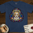 How Great Thou Bark Coton de Tulear T-Shirt flat lay in True Navy, featuring a full-color stained-glass saint window of a sable and white Coton de Tulear facing forward, haloed in golden light.