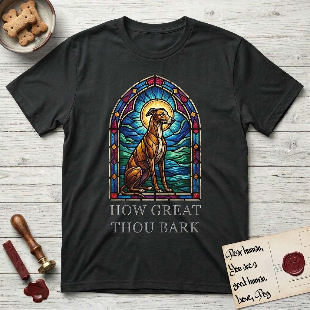 How Great Thou Bark Greyhound T-Shirt flat lay in Black, featuring a full-color stained-glass saint window of a Greyhound sitting in stillness, with a halo.