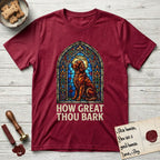 How Great Thou Bark Irish Setter T-Shirt flat lay in Antique Cherry Red, featuring a full-color stained-glass saint window of an Irish Setter seated and gazing up into the light, with a halo.