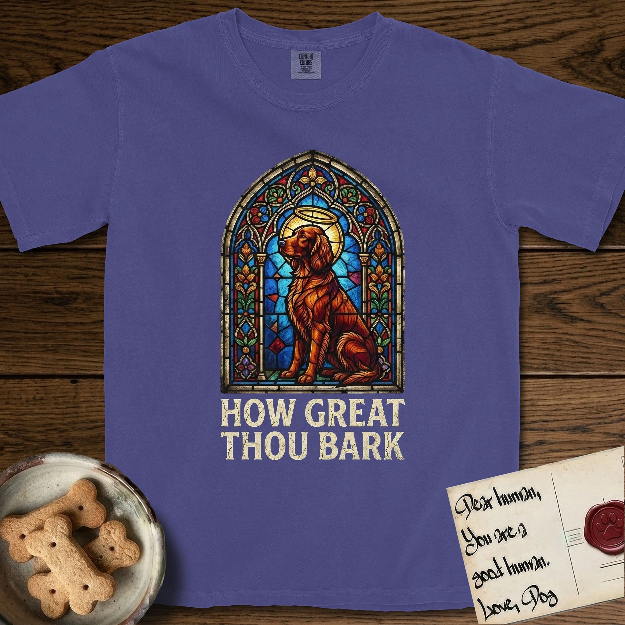 How Great Thou Bark Irish Setter T-Shirt flat lay in Grape, featuring a full-color stained-glass saint window of an Irish Setter seated and gazing up into the light, with a halo.