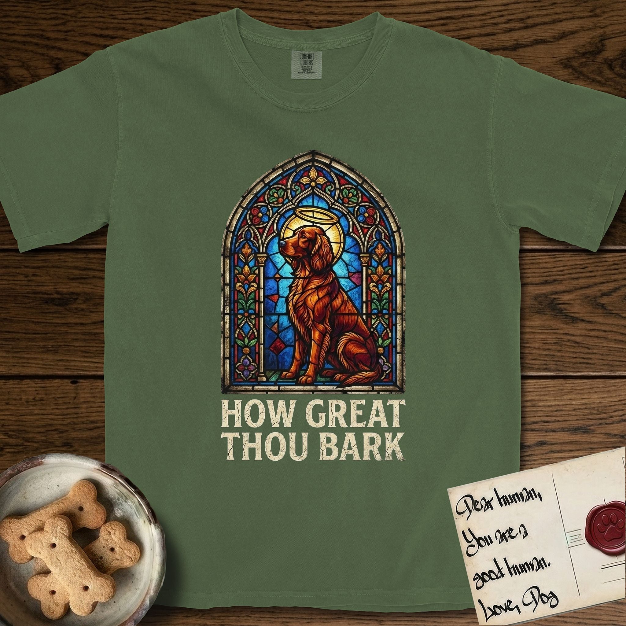 How Great Thou Bark Irish Setter T-Shirt flat lay in Moss, featuring a full-color stained-glass saint window of an Irish Setter seated and gazing up into the light, with a halo.