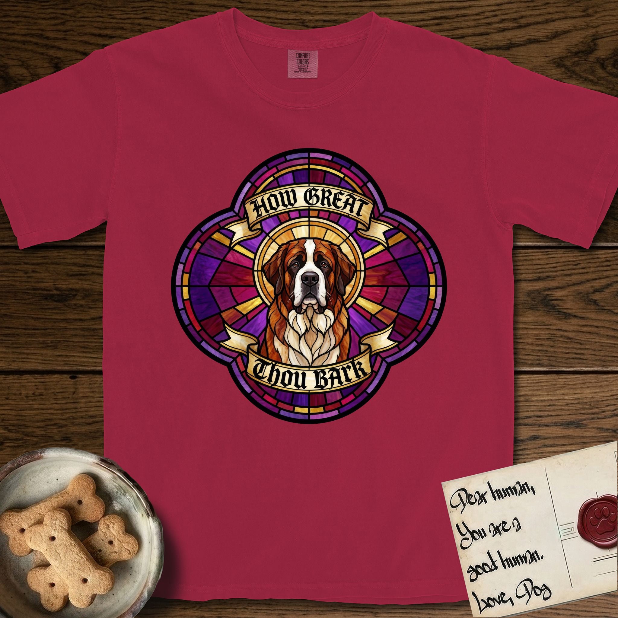How Great Thou Bark Saint Bernard T-Shirt flat lay in Chili, featuring a full-color stained-glass saint window of a red and white Saint Bernard facing forward, haloed in golden light.