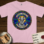 How Great Thou Bark Schnauzer T-Shirt flat lay in Blossom, featuring a full-color stained-glass saint window of a salt-and-pepper Schnauzer with bushy eyebrows and beard, haloed in golden light.