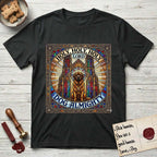 Holy Holy Holy Newfoundland T-Shirt flat lay in Black, featuring a gothic stained-glass window in jewel tones with a Newfoundland at center, Celtic knotwork border, corner paw prints, and the words Holy Holy Holy and Dog Almighty.