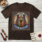 Holy Holy Holy Newfoundland T-Shirt flat lay in Dark Chocolate, featuring a gothic stained-glass window in jewel tones with a Newfoundland at center, Celtic knotwork border, corner paw prints, and the words Holy Holy Holy and Dog Almighty.