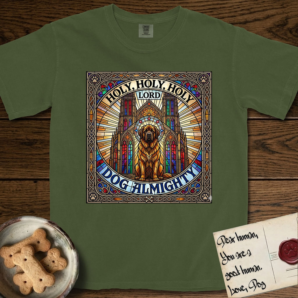 Holy Holy Holy Newfoundland T-Shirt flat lay in Hemp, featuring a gothic stained-glass window in jewel tones with a Newfoundland at center, Celtic knotwork border, corner paw prints, and the words Holy Holy Holy and Dog Almighty.