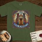 Holy Holy Holy Newfoundland T-Shirt flat lay in Hemp, featuring a gothic stained-glass window in jewel tones with a Newfoundland at center, Celtic knotwork border, corner paw prints, and the words Holy Holy Holy and Dog Almighty.