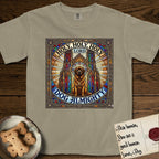 Holy Holy Holy Newfoundland T-Shirt flat lay in Khaki, featuring a gothic stained-glass window in jewel tones with a Newfoundland at center, Celtic knotwork border, corner paw prints, and the words Holy Holy Holy and Dog Almighty.