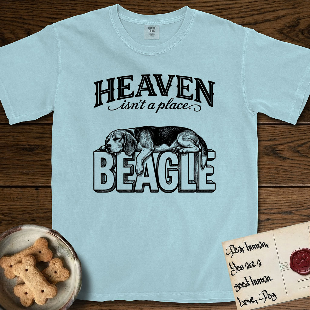Heaven Isn't a Place Beagle T-Shirt flat lay in Chambray, featuring Black ink engraving illustration of a tricolor Beagle asleep on top of the giant carved block letters BEAGLE, under the lettering HEAVEN isn't a place..