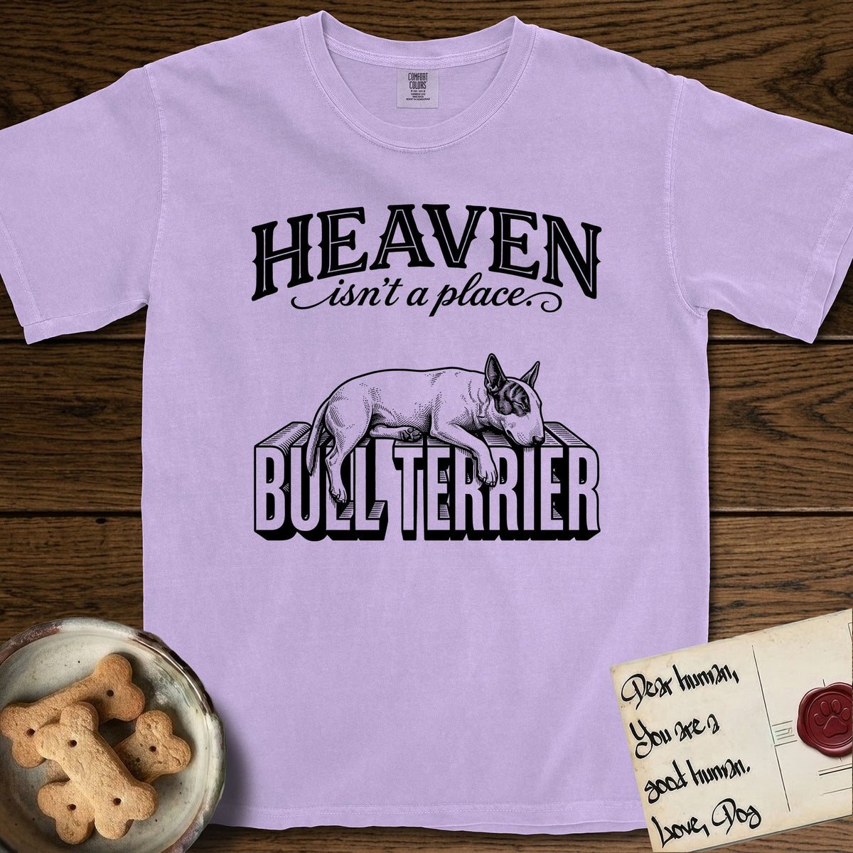 Heaven Isn't a Place Bull Terrier T-Shirt flat lay in Orchid, featuring Black ink engraving illustration of a Bull Terrier with a dark patch over one eye asleep on top of the giant carved block letters BULL TERRIER, under the lettering HEAVEN isn't a place..