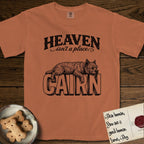 Heaven Isn't a Place Cairn Terrier T-Shirt flat lay in Yam, featuring Black ink engraving illustration of a shaggy Cairn Terrier asleep on top of the giant carved block letters CAIRN, under the lettering HEAVEN isn't a place..