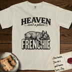 Heaven Isn't a Place French Bulldog T-Shirt flat lay in Ivory, featuring Black ink engraving illustration of a brindle French Bulldog asleep on top of the giant carved block letters FRENCHIE, under the lettering HEAVEN isn't a place..