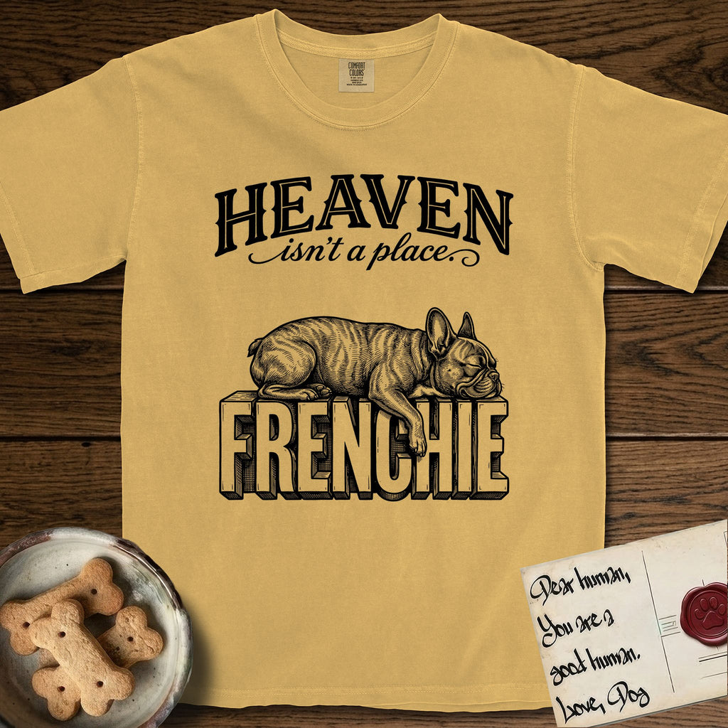 Heaven Isn't a Place French Bulldog T-Shirt flat lay in Mustard, featuring Black ink engraving illustration of a brindle French Bulldog asleep on top of the giant carved block letters FRENCHIE, under the lettering HEAVEN isn't a place..