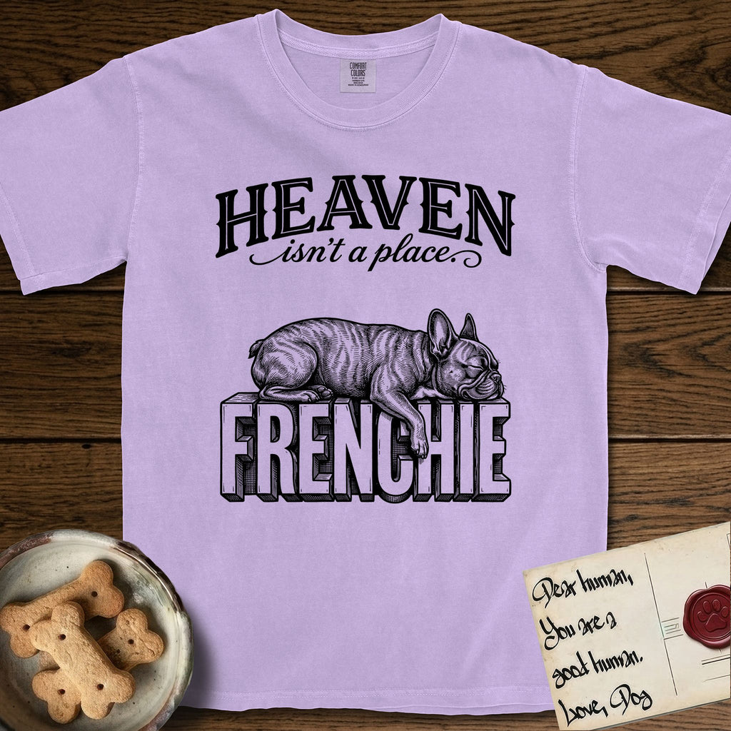 Heaven Isn't a Place French Bulldog T-Shirt flat lay in Orchid, featuring Black ink engraving illustration of a brindle French Bulldog asleep on top of the giant carved block letters FRENCHIE, under the lettering HEAVEN isn't a place..
