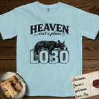 Heaven Isn't a Place Lobo T-Shirt flat lay in Chambray, featuring Black ink engraving illustration of Lobo, a black-and-white Cattle Dog and Pitbull mix with a white blaze, asleep on top of the giant carved block letters LOBO, under the lettering HEAVEN isn't a place..