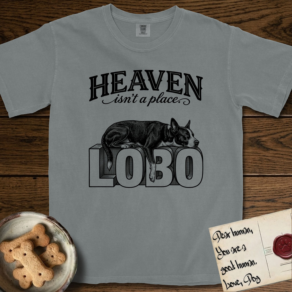 Heaven Isn't a Place Lobo T-Shirt flat lay in Granite, featuring Black ink engraving illustration of Lobo, a black-and-white Cattle Dog and Pitbull mix with a white blaze, asleep on top of the giant carved block letters LOBO, under the lettering HEAVEN isn't a place..