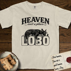 Heaven Isn't a Place Lobo T-Shirt flat lay in Ivory, featuring Black ink engraving illustration of Lobo, a black-and-white Cattle Dog and Pitbull mix with a white blaze, asleep on top of the giant carved block letters LOBO, under the lettering HEAVEN isn't a place..