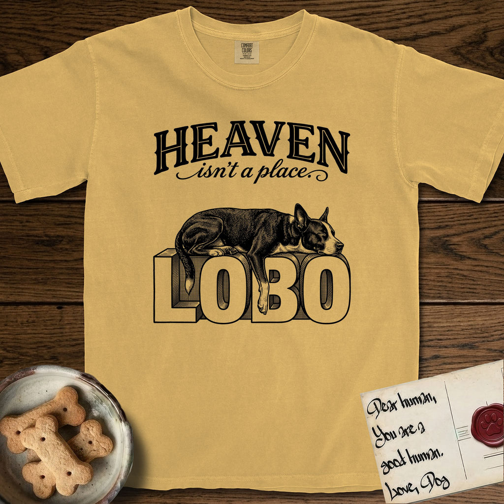 Heaven Isn't a Place Lobo T-Shirt flat lay in Mustard, featuring Black ink engraving illustration of Lobo, a black-and-white Cattle Dog and Pitbull mix with a white blaze, asleep on top of the giant carved block letters LOBO, under the lettering HEAVEN isn't a place..