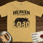 Heaven Isn't a Place Lobo T-Shirt flat lay in Mustard, featuring Black ink engraving illustration of Lobo, a black-and-white Cattle Dog and Pitbull mix with a white blaze, asleep on top of the giant carved block letters LOBO, under the lettering HEAVEN isn't a place..