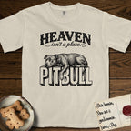 Heaven Isn't a Place Pitbull T-Shirt flat lay in Ivory, featuring Black ink engraving illustration of a Pitbull asleep on top of the giant carved block letters PITBULL, under the lettering HEAVEN isn't a place..
