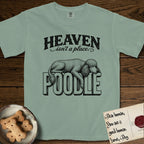 Heaven Isn't a Place Poodle T-Shirt flat lay in Bay, featuring Black ink engraving illustration of a curly Standard Poodle asleep on top of the giant carved block letters POODLE, under the lettering HEAVEN isn't a place..