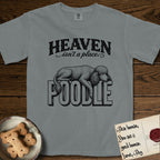 Heaven Isn't a Place Poodle T-Shirt flat lay in Granite, featuring Black ink engraving illustration of a curly Standard Poodle asleep on top of the giant carved block letters POODLE, under the lettering HEAVEN isn't a place..