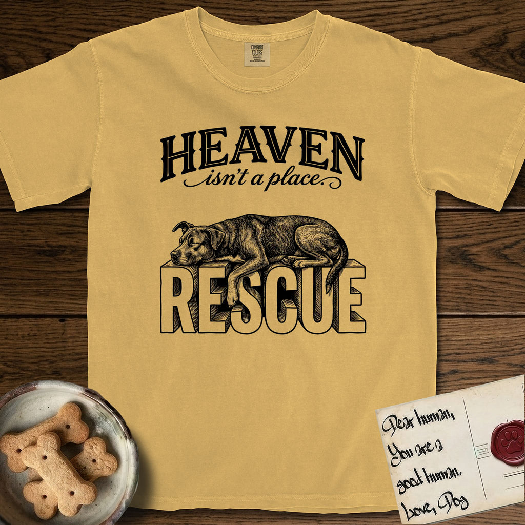 Heaven Isn't a Place Rescue Mutt T-Shirt flat lay in Mustard, featuring Black ink engraving illustration of a rescue Dog that is a Lab, Shepherd and Pitbull mix asleep on top of the giant carved block letters RESCUE, under the lettering HEAVEN isn't a place..