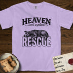 Heaven Isn't a Place Rescue Mutt T-Shirt flat lay in Orchid, featuring Black ink engraving illustration of a rescue Dog that is a Lab, Shepherd and Pitbull mix asleep on top of the giant carved block letters RESCUE, under the lettering HEAVEN isn't a place..