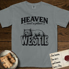 Heaven Isn't a Place Westie T-Shirt flat lay in Granite, featuring Black ink engraving illustration of a Westie asleep on top of the giant carved block letters WESTIE, under the lettering HEAVEN isn't a place..