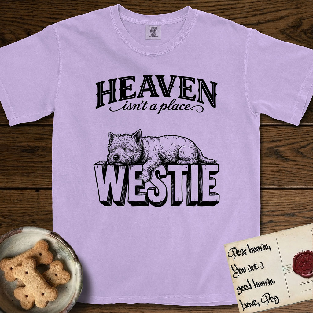 Heaven Isn't a Place Westie T-Shirt flat lay in Orchid, featuring Black ink engraving illustration of a Westie asleep on top of the giant carved block letters WESTIE, under the lettering HEAVEN isn't a place..