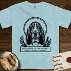 Holy Orders Basset Hound T-Shirt flat lay in Chambray, featuring a bold black-and-white linocut saint-medallion portrait of a Basset Hound.