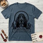 Holy Orders Basset Hound T-Shirt flat lay in Indigo Blue, featuring a bold black-and-white linocut saint-medallion portrait of a Basset Hound.