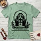 Holy Orders Basset Hound T-Shirt flat lay in Mint Green, featuring a bold black-and-white linocut saint-medallion portrait of a Basset Hound.