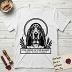 Holy Orders Basset Hound T-Shirt flat lay in White, featuring a bold black-and-white linocut saint-medallion portrait of a Basset Hound.