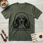 Holy Orders Beagle T-Shirt flat lay in Heather Military Green, featuring a bold black-and-white linocut saint-medallion portrait of a Beagle.
