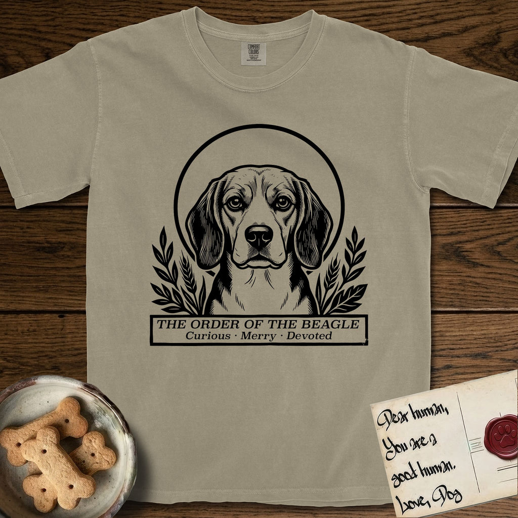 Holy Orders Beagle T-Shirt flat lay in Khaki, featuring a bold black-and-white linocut saint-medallion portrait of a Beagle.