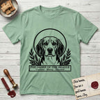 Holy Orders Beagle T-Shirt flat lay in Mint Green, featuring a bold black-and-white linocut saint-medallion portrait of a Beagle.