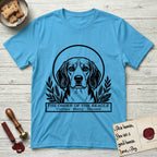 Holy Orders Beagle T-Shirt flat lay in Sky, featuring a bold black-and-white linocut saint-medallion portrait of a Beagle.