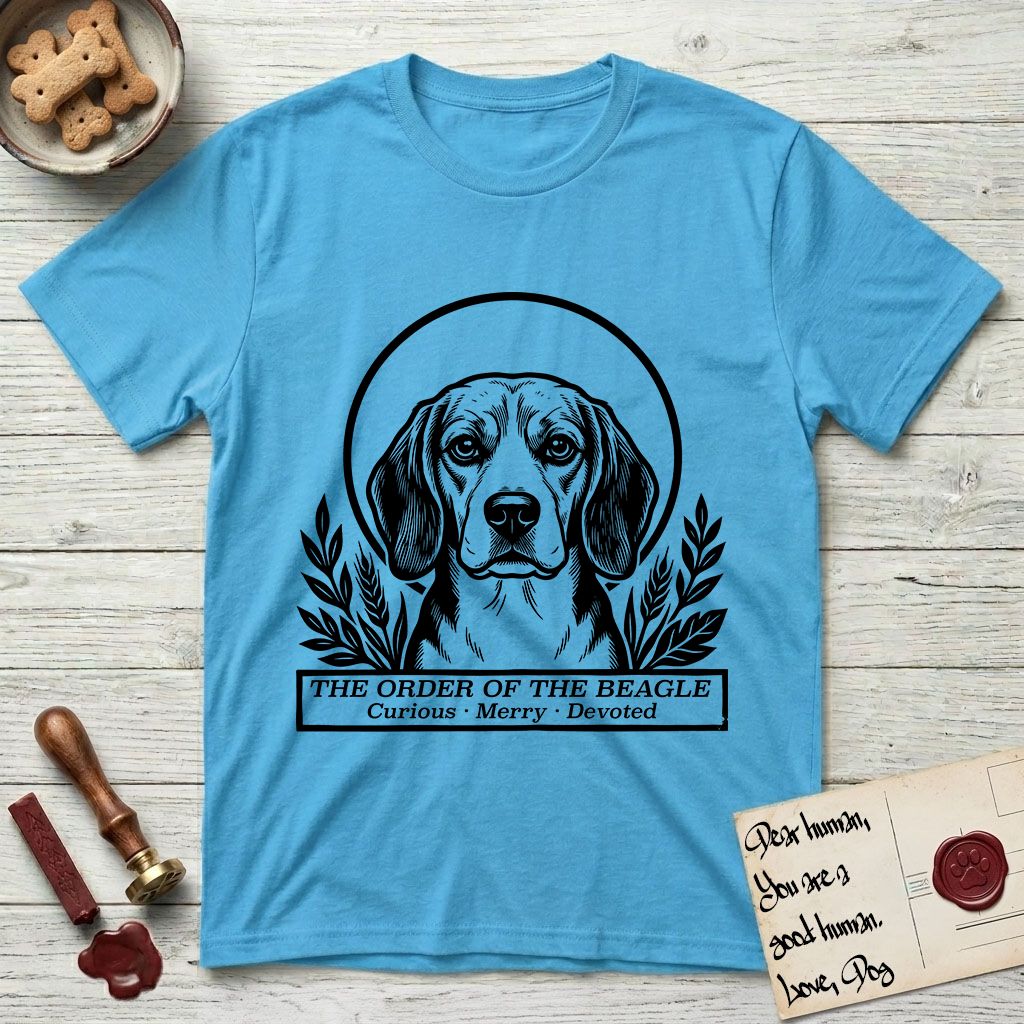 Holy Orders Beagle T-Shirt flat lay in Sky, featuring a bold black-and-white linocut saint-medallion portrait of a Beagle.