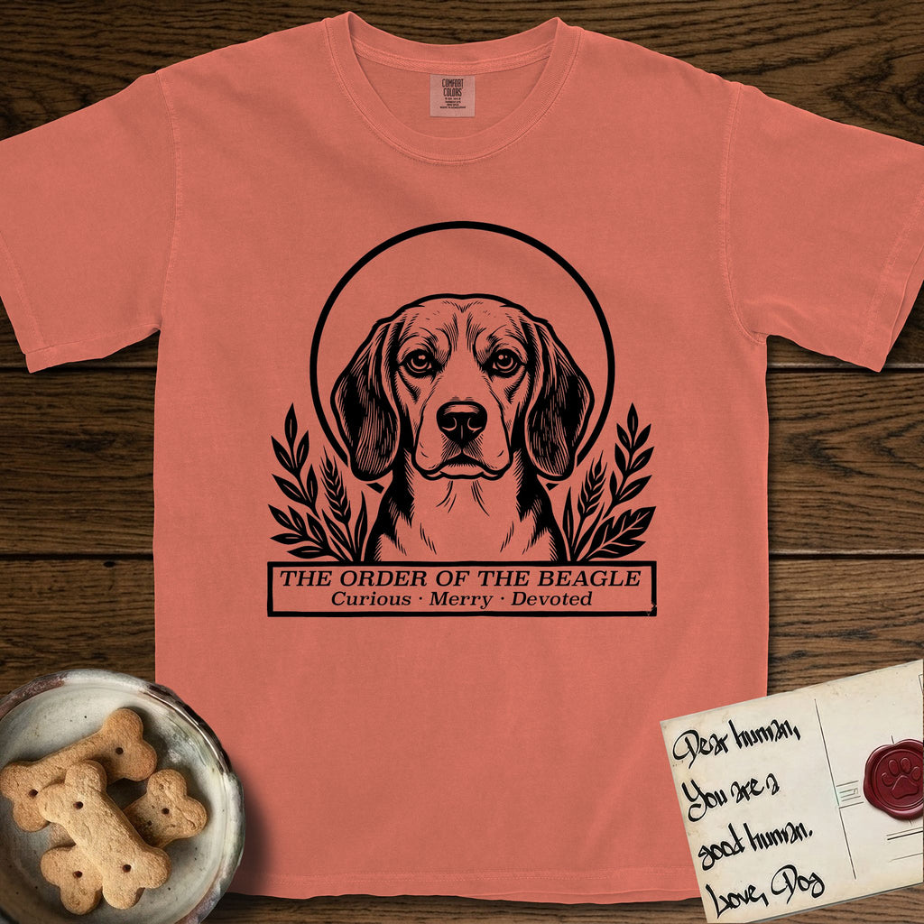 Holy Orders Beagle T-Shirt flat lay in Terracotta, featuring a bold black-and-white linocut saint-medallion portrait of a Beagle.