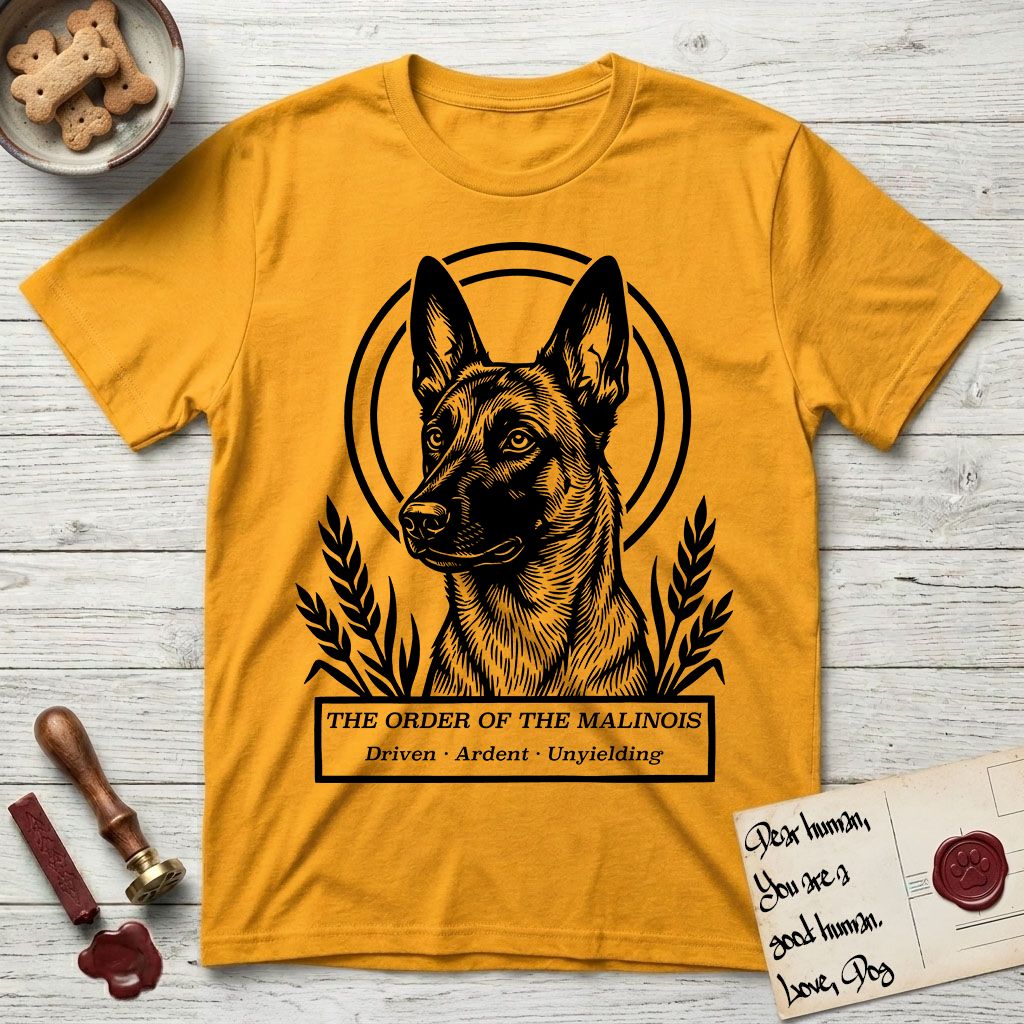 Holy Orders Belgian Malinois T-Shirt flat lay in Gold, featuring a bold black-and-white linocut saint-medallion portrait of a Belgian Malinois.